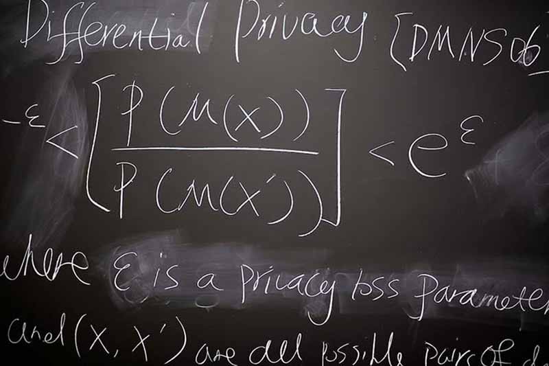A black board with words and equations written in white chalk.