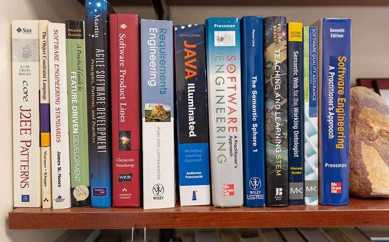 Books about software and engineering sit on a bookshelf.